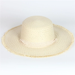 Close-up of beige straw hat with delicate lace trim and trendy frayed edge texture