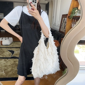 Close-up of a white fringe tassel tote bag showing its dense feather-like texture