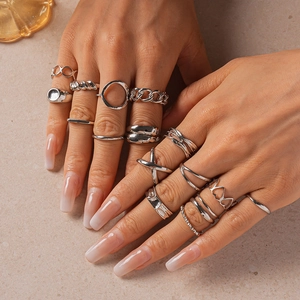 Close-up of 16-piece silver geometric ring set with hollow hearts and chain designs