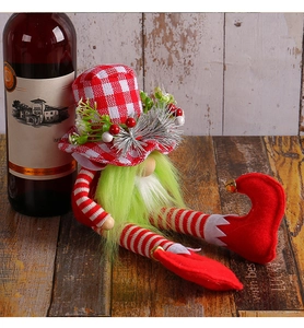 Detail of a Christmas gnome with green beard, red-white plaid hat and tiny bells on boots