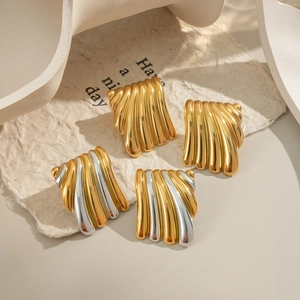Boucles d'oreilles géométriques minimalistes en or et argent sur fond de papier