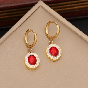 Gold stainless steel hoop earrings with red zircon and pearl charms in a jewelry box