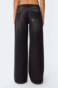Détail d'un jean large taille haute gris foncé avec un grand motif papillon sur le dos du pantalon
