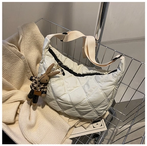 Close-up of white quilted crossbody bag featuring a cute brown plaid rabbit charm accessory