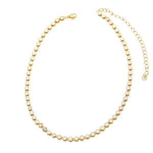 Detail of gold tennis necklace with bezel-set round cubic zirconia and lobster clasp