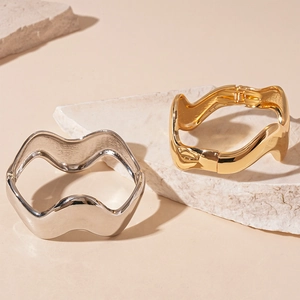 Polished metallic wavy bangles in gold and silver finish with minimalist modern design