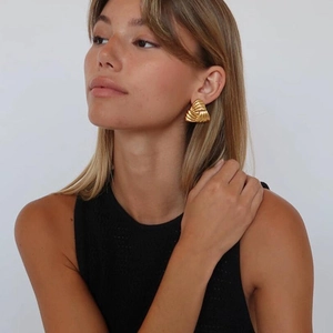 Chic golden triangular feather-textured earrings on female model with minimalist style
