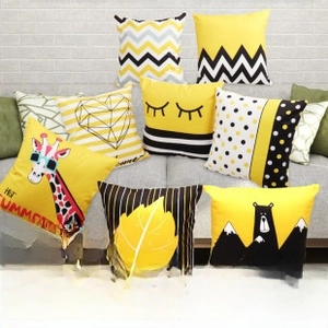Detail of assorted polyester star and geometric print pillow covers on a sofa