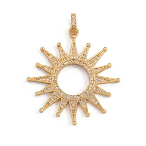 Macro view of sunburst charm with white cubic zirconia inlay and gold plating