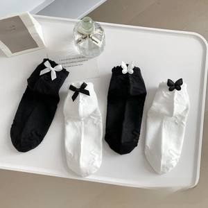 Detailed view of white and black JK style cotton socks with satin bows and floral patterns