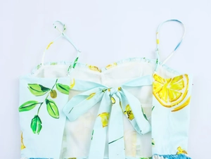 Dettaglio dell'abito con stampa limoni che mostra il fiocco posteriore e spalline