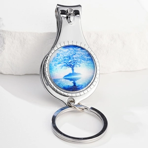 Detail of tree of life bottle opener keychain with blue resin charm on white stone