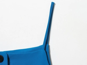 Gros plan sur la bandoulière et le revers du blazer bleu avec détail de bouton noir