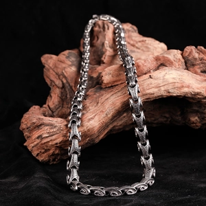 Macro detail of vintage dragon scale texture on stainless steel punk necklace