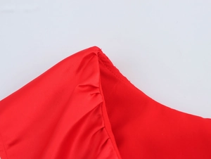 Gros plan détaillé sur l'épaule à volants rouge et la texture du tissu satiné de l'ensemble