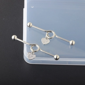 Macro view of a stainless steel heart industrial barbell with inlaid small rhinestones