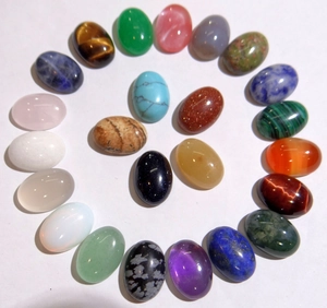 Close-up of assorted 10x14mm oval natural crystal cabochons in a spiral arrangement
