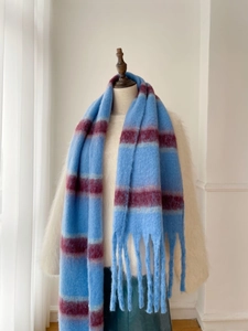 Close-up of blue and maroon striped scarf with thick fringe tassels and plush texture