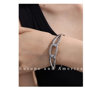 Macro detail of high-polish silver interlocking metal chain links on a minimalist bracelet