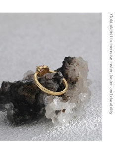Macro shot of gold plated ring featuring a pink heart zircon and beaded side details