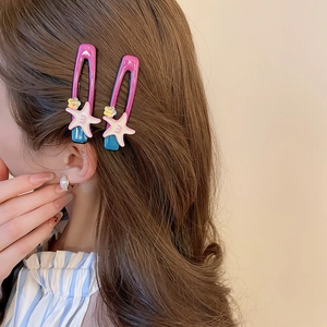 Detail of pink and blue resin star hair clips with white starfish and yellow flower design