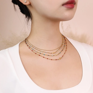 Three-layer gold Ankh cross necklace with colorful beads on a fashion model