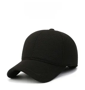 Close-up of thick winter wool blend newsboy cap with circular metal logo on black fabric
