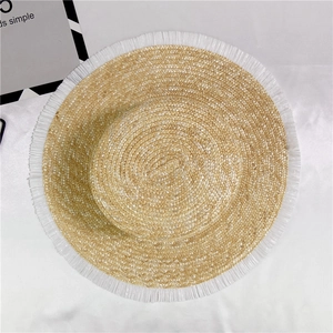 Flat lay of a straw boater hat with white frayed fringe edges and minimalist card