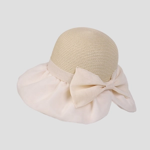 Dettaglio cappello di paglia elegante da donna con grande fiocco in chiffon e trama tessuta