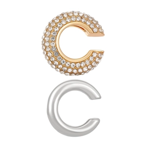 Détail de boucles d'oreilles C avec un style pavé de strass dorés et un anneau argenté poli