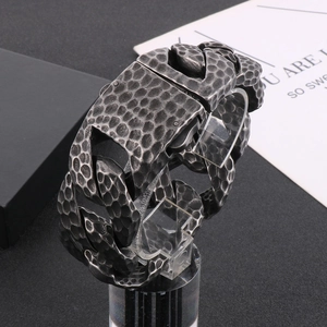 Detail of vintage hammered texture and heavy metal chain links on steel bracelet