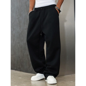 Detail of men's black sweatpants featuring a drawstring waistband and premium knit fabric