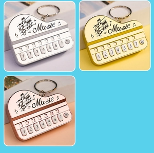 Three-color piano keyboard keychains in silver, gold, and rose gold finishes