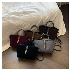 Présentation de cinq sacs à main en daim colorés avec boucles dorées ovales élégantes