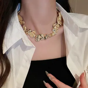Golden irregular lava textured statement necklace worn by model on white shirt