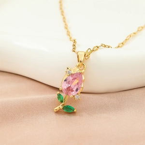 Macro shot of tulip flower pendant necklace with pink cubic zirconia and gold finish