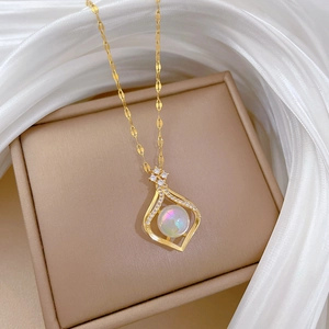 Nahaufnahme der goldenen Titan-Halskette mit Tropfenanhänger und schimmerndem Opal