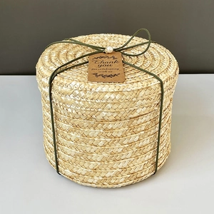 Detail of woven straw gift box with green ribbon, pearl decor, and Thank You tag