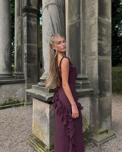 Detail of elegant deep purple backless dress with ruffled edges and side slit design