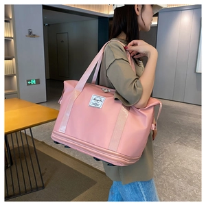Pink waterproof travel bag with expansion base shown being carried by a model