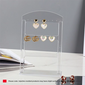 Three-layer clear acrylic earring holder with 24 holes showing various stud earrings