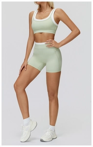 Detail of high-stretch two-piece yoga set with color-block bra and high-waist shorts