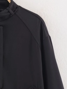 Vista dettagliata della trama del tessuto twill nero sulla giacca moda autunno a maniche