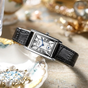 Macro shot of a vintage square silver watch with Roman numerals and blue hands