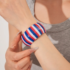 Close-up of red white and blue striped wide cuff bracelet worn on a female wrist