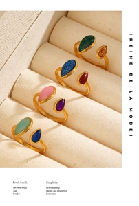 Detailed view of adjustable gold-plated teardrop rings with vibrant colorful stones