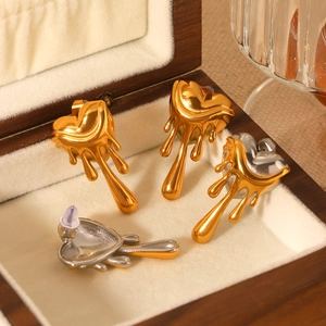 Minimalist melting lava heart earrings in gold and silver finish on a wooden jewelry box