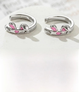 Detail of silver bunny ear ear cuffs made of titanium steel with pink enamel and zircons