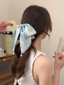 Detail of blue starry tie-dye bow hair scrunchie with elegant hanging pearl charm