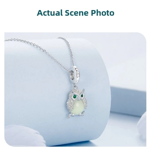 Detailed view of luminous owl pendant in S925 sterling silver with green gem eyes
